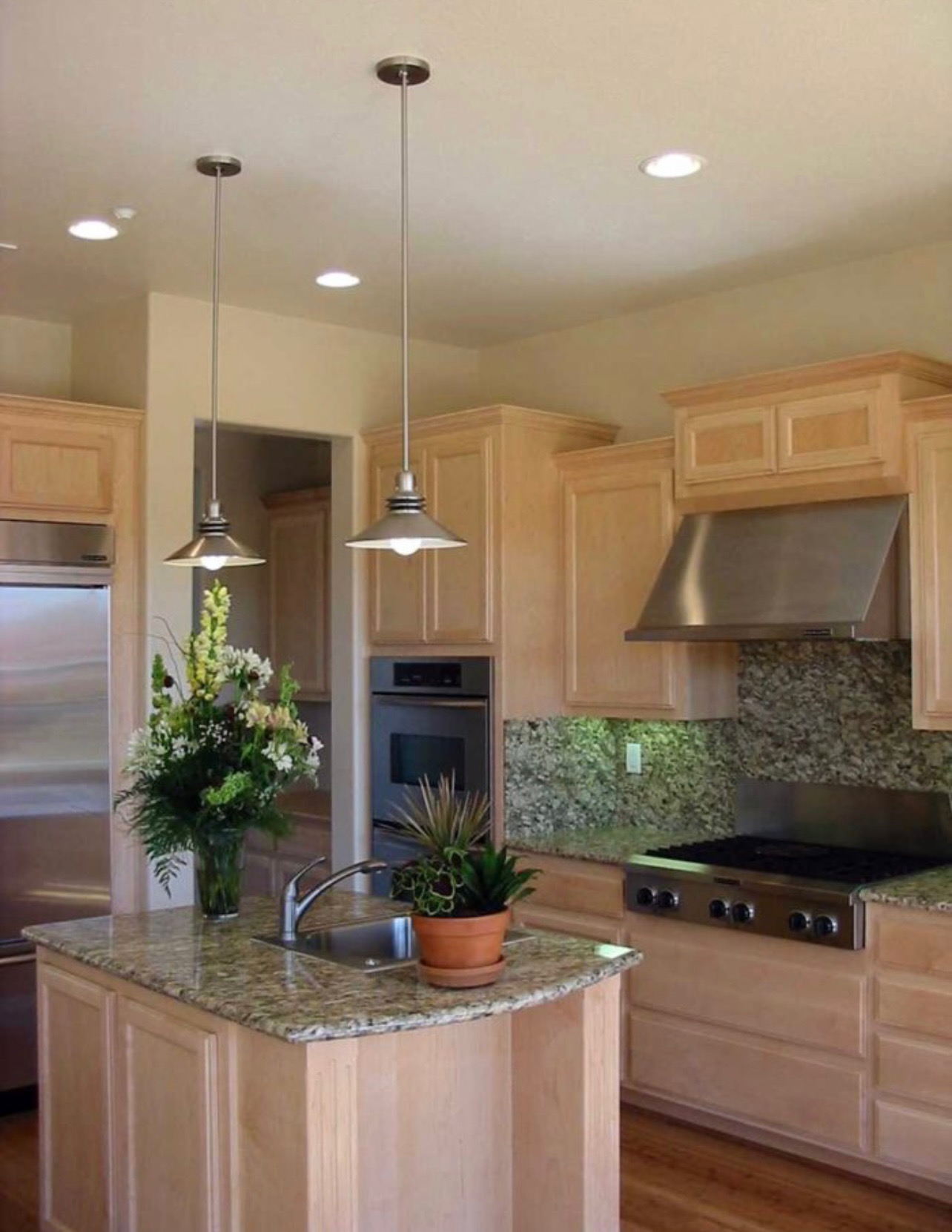 Recessed lighting paired with pendant fixtures over a kitchen island