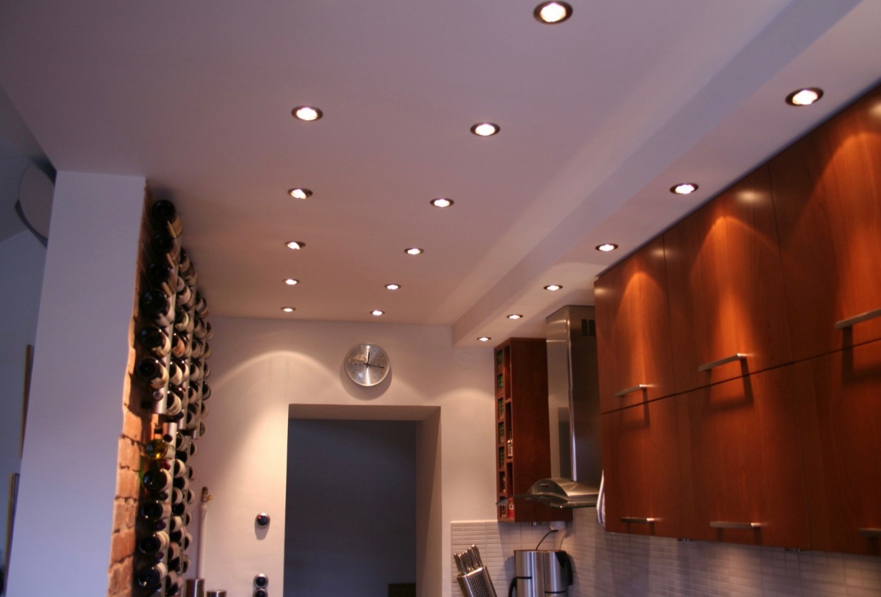 Custom recessed lighting layout over a kitchen and wine wall